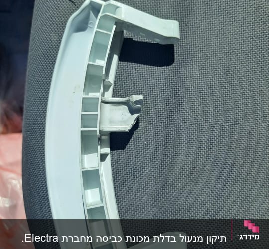 חלק פלסטיק לבן שבור על רקע בד אפור